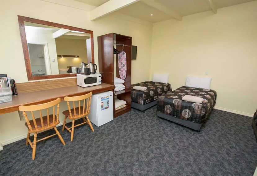A twin queen room with two queen beds, a desk, microwave and bar fridge