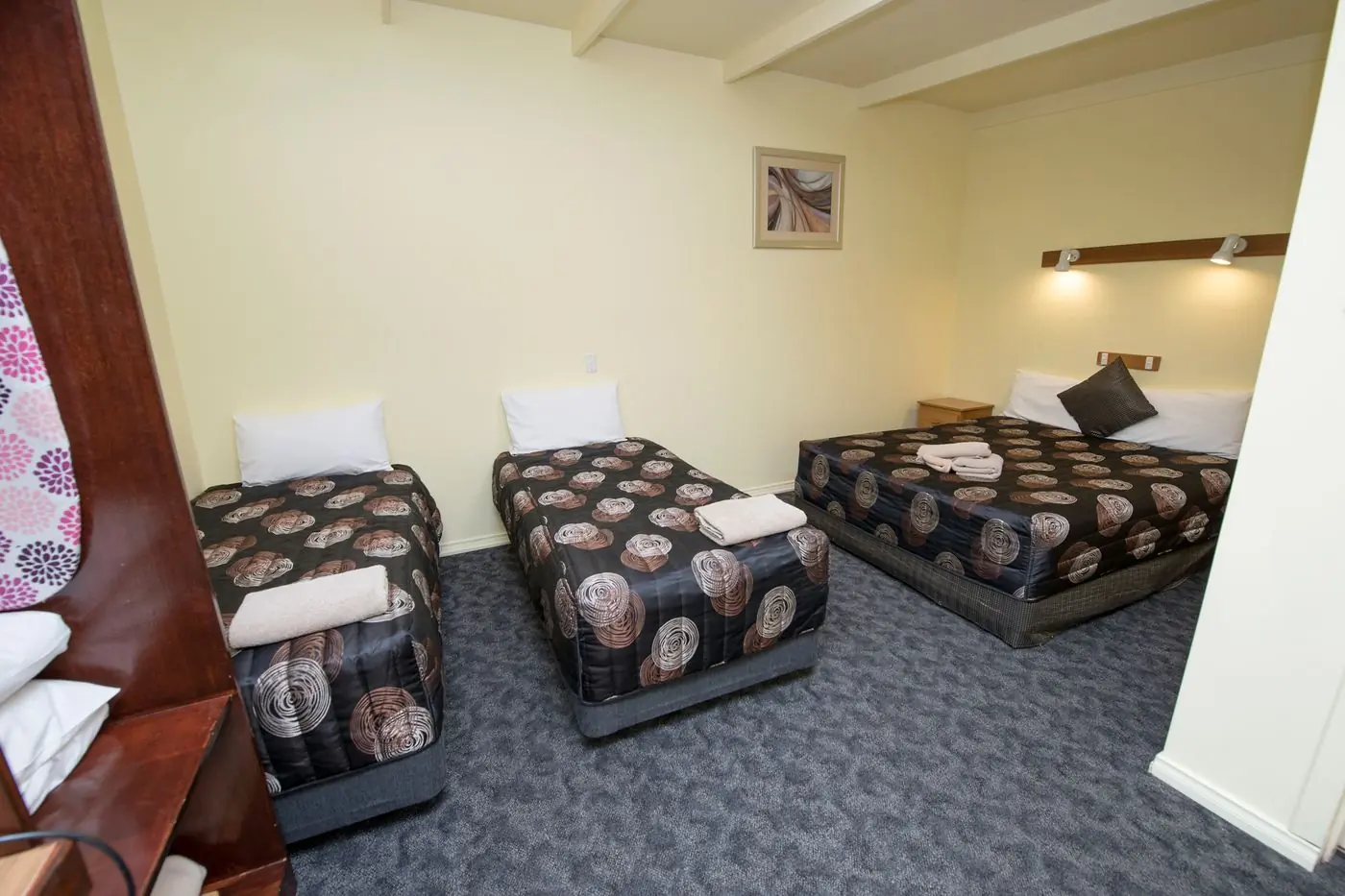 A family room with a queen bed and two single beds