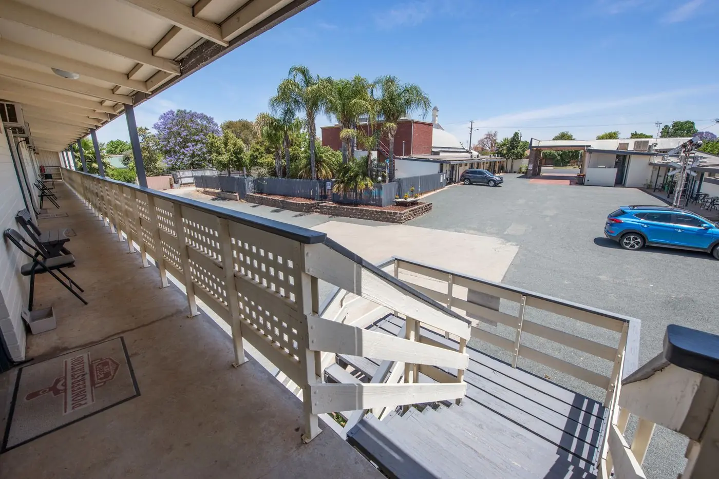 The first-floor verandah and timber staircase overlooking the car park