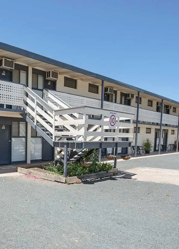 The two-storey motel building and its white timber staircase