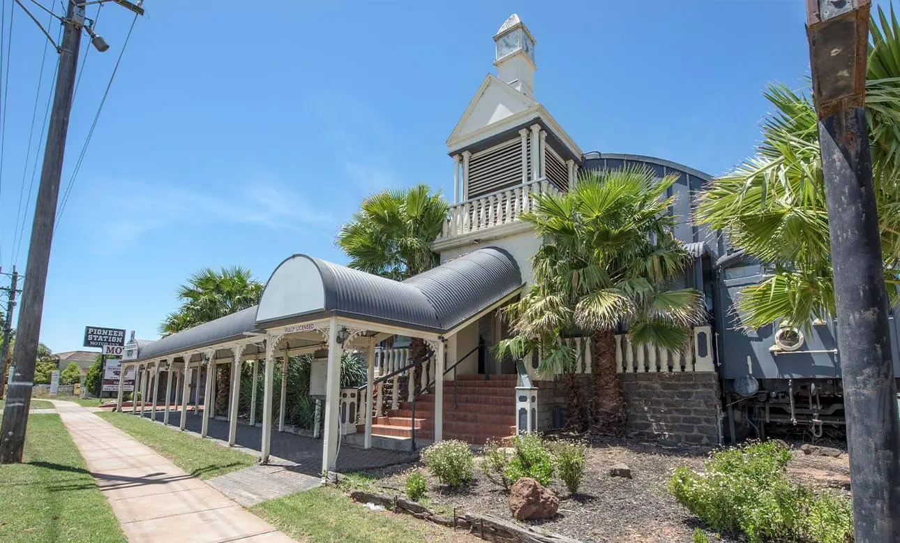 The heritage railway station building with its clock tower and palm trees